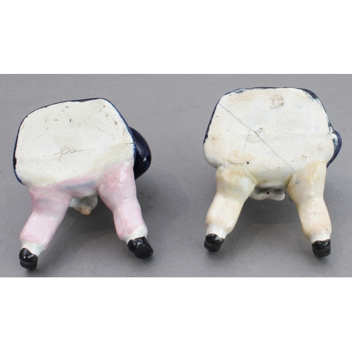 31 - A pair of 19th century seated Staffordshire figures (as pots with removeable hats, minor damage) (8.... 
