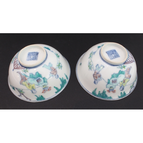 34 - A pair of modern Chinese porcelain bowls in 18th century style: each decorated with an exterior scen... 