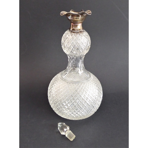 52 - Four quality glass decanters:
 a modern hand-cut mallet-shaped decanter and stopper ;
 a hand-cut sp... 