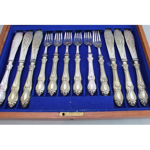 76 - An early 20th century walnut-cased set of 12 silver-plated fish eaters; the blades and fork heads en... 