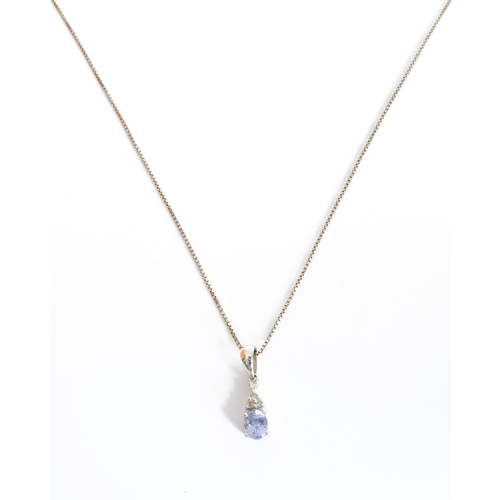 106 - A silver pendant set with a hand-cut oval tanzanite: below four further smaller white stone chips (p... 