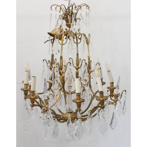 56A - A large and showy pair of gilt metal and cut-glass, 12 light chandeliers: varying tiers with individ... 