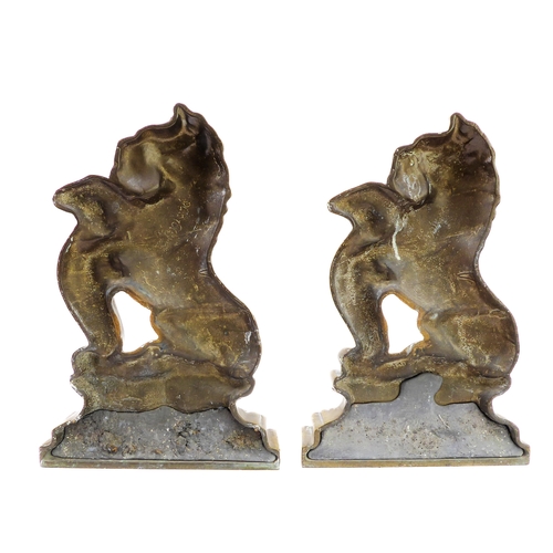 49 - A good and unusual pair of brass and lead-weighted doorstops modelled as lions coward (34 cm high)