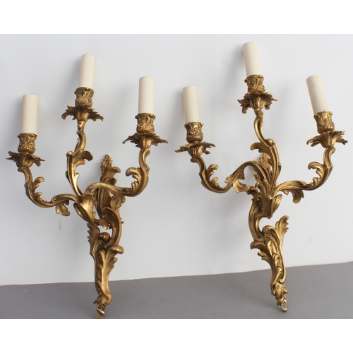 54 - A pair of early 20th century gilt-metal three-light wall appliques in high mid-18th century Rococo s... 