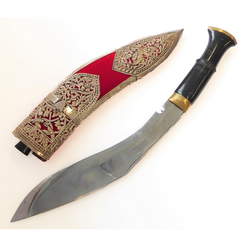 131 - A modern kukri and white-metal-mounted Saudi-style red-felt sheath: heavy carved handle with brass c... 