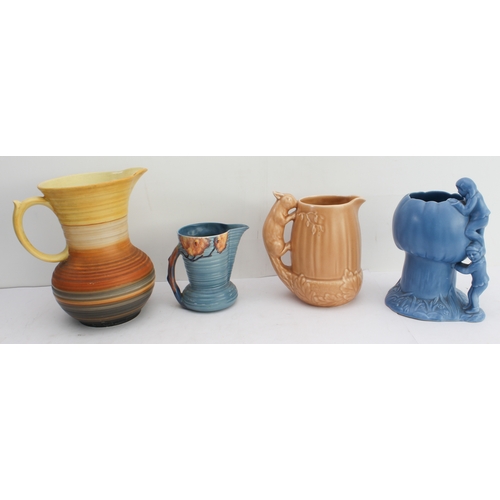 12 - Four ceramic jugs:
 an Art Deco Shelley example with reeded body and varying colours (34 cm high);
 ... 