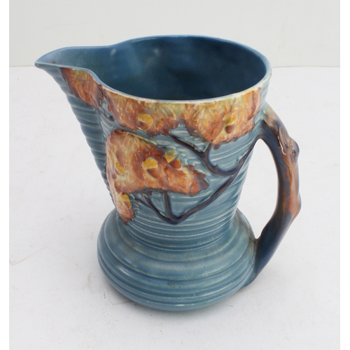 12 - Four ceramic jugs:
 an Art Deco Shelley example with reeded body and varying colours (34 cm high);
 ... 