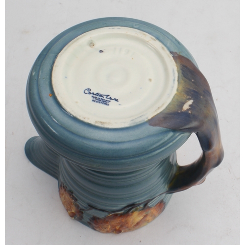 12 - Four ceramic jugs:
 an Art Deco Shelley example with reeded body and varying colours (34 cm high);
 ... 