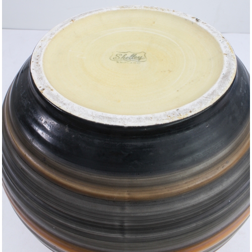 12 - Four ceramic jugs:
 an Art Deco Shelley example with reeded body and varying colours (34 cm high);
 ... 