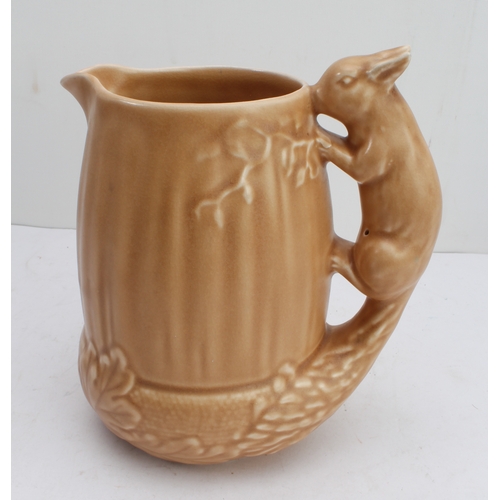 12 - Four ceramic jugs:
 an Art Deco Shelley example with reeded body and varying colours (34 cm high);
 ... 