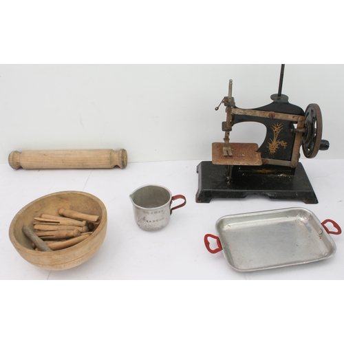 148 - An assortment of children's toys to include:
 two tinplate engines;
 a bell-pistol;
 kitchenware to ... 