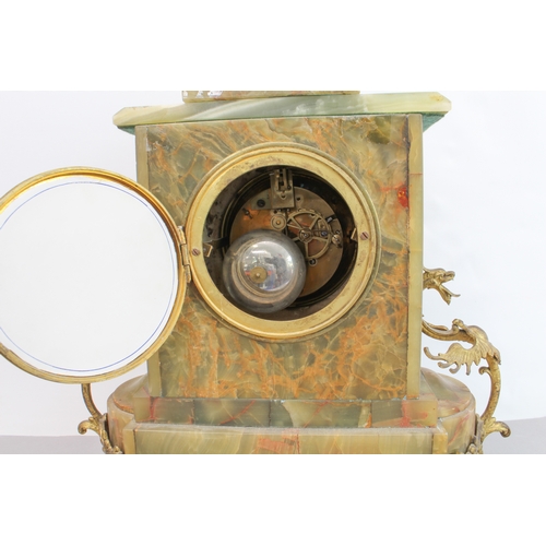 125 - A late 19th century gilt-metal-mounted and onyx-cased eight-day mantle clock: the white enamel dial ... 