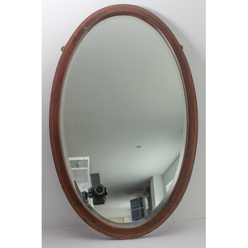 289 - Two mirrors:
 1. an early 20th century oval mahogany and boxwood-strung wall-hanging looking glass h... 