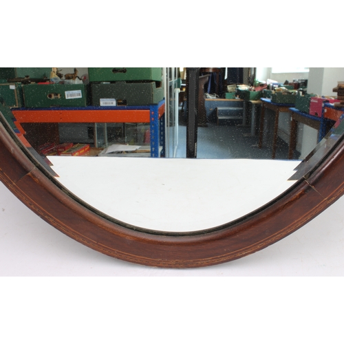 289 - Two mirrors:
 1. an early 20th century oval mahogany and boxwood-strung wall-hanging looking glass h... 