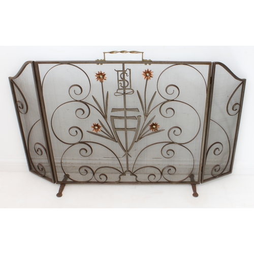 101 - An Arts and Crafts style wrought-iron and wire-mesh folding fire screen: barleytwist brass handle; w... 