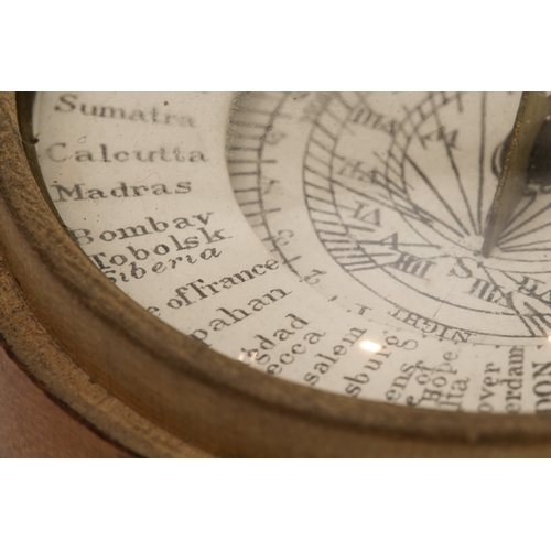 127 - An early 19th century pocket sun-dial and compass set in a turned sycamore case: the central raised ... 