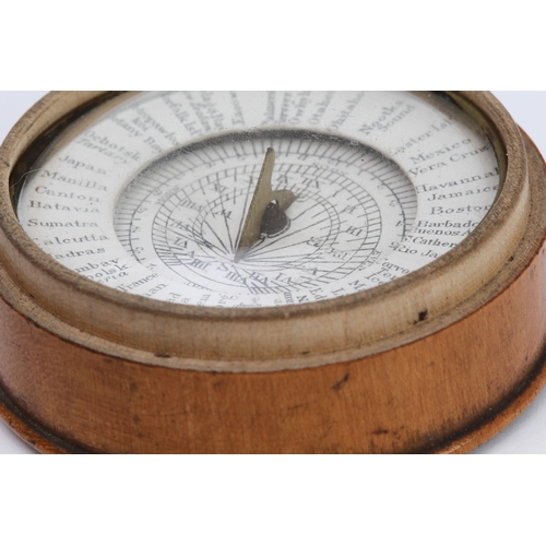 127 - An early 19th century pocket sun-dial and compass set in a turned sycamore case: the central raised ... 