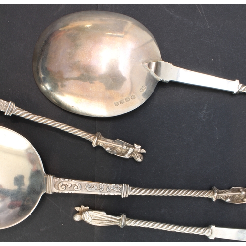 157 - A cased set of four hallmarked silver serving spoons; each with engraved scrollwork-style decoration... 