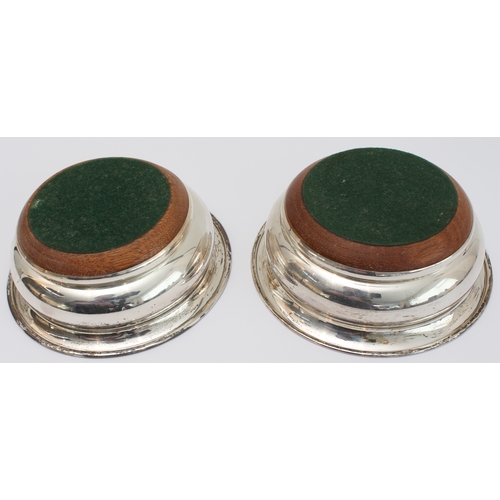 180 - A pair of modern hallmarked silver wine bottle coasters with turned wooden bases: maker's mark PHV &... 