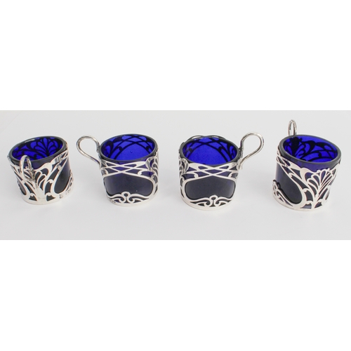 187 - A set of four coffee cans with cobalt-blue glass liners and pierced hallmarked silver outers in Art ... 