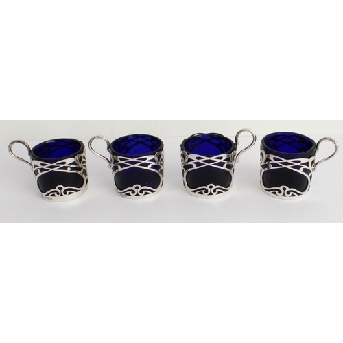 187 - A set of four coffee cans with cobalt-blue glass liners and pierced hallmarked silver outers in Art ... 