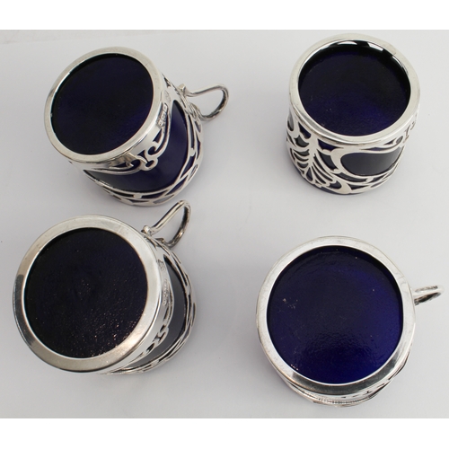 187 - A set of four coffee cans with cobalt-blue glass liners and pierced hallmarked silver outers in Art ... 