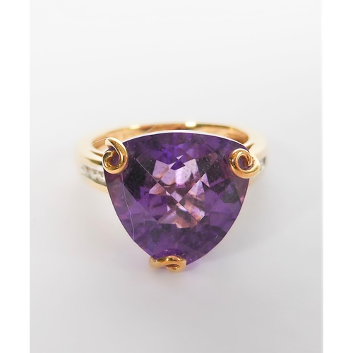 211 - A 9-carat yellow gold dress ring: centrally set with a trillion-cut amethyst of good colour, unusual... 