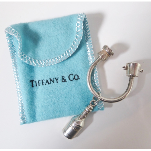 221 - A genuine Tiffany & Co. silver key ring modelled as a champagne bottle hanging from a U-shaped suspe... 