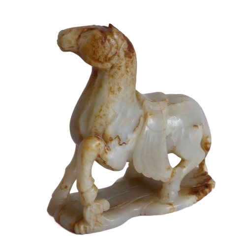 38 - Qing Dynasty (1644-1911) - a large and heavy pale-celadon and russet jade carving of a saddled horse... 