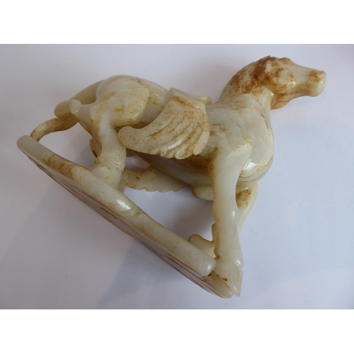 38 - Qing Dynasty (1644-1911) - a large and heavy pale-celadon and russet jade carving of a saddled horse... 