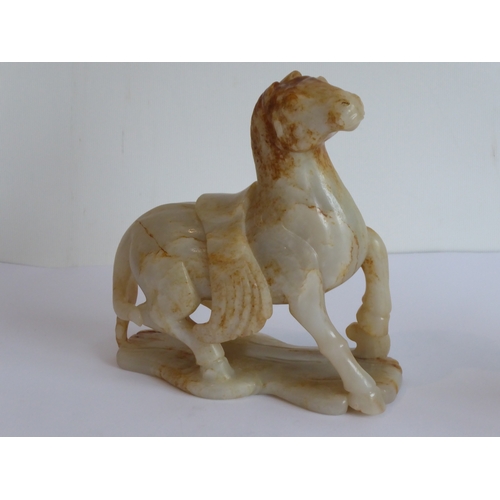 38 - Qing Dynasty (1644-1911) - a large and heavy pale-celadon and russet jade carving of a saddled horse... 