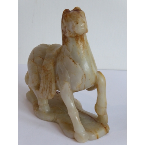 38 - Qing Dynasty (1644-1911) - a large and heavy pale-celadon and russet jade carving of a saddled horse... 