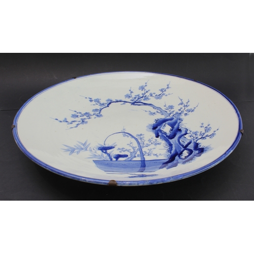 50 - A large late 19th century Japanese porcelain charger: hand-decorated in underglaze blue with blue ri... 