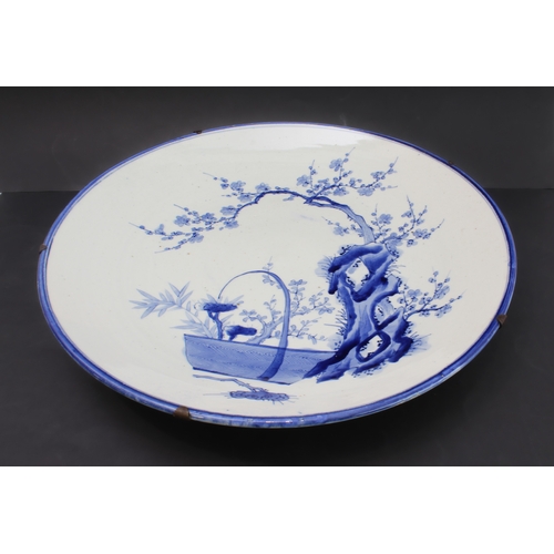 50 - A large late 19th century Japanese porcelain charger: hand-decorated in underglaze blue with blue ri... 