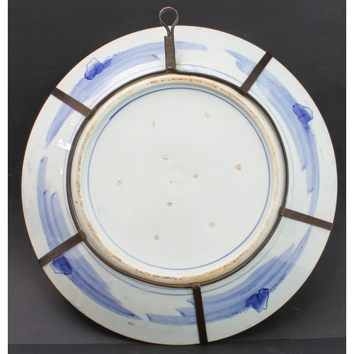 50 - A large late 19th century Japanese porcelain charger: hand-decorated in underglaze blue with blue ri... 