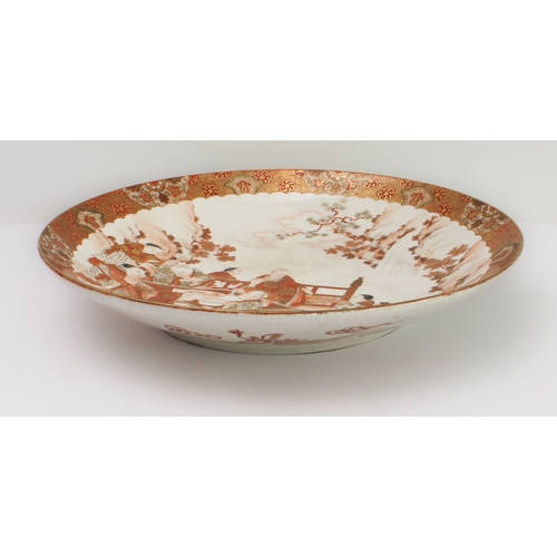 67 - A large Japanese earthenware Kutani dish
 Meiji period (1868-1912), finely painted with a feasting s... 