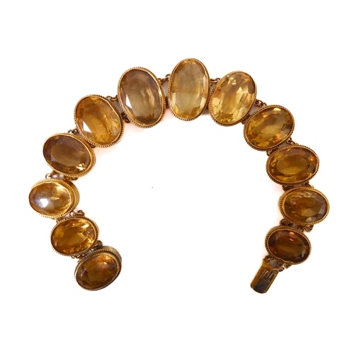 223 - A 19th century bracelet (tests as gold) mounted with 12 graduated hand-cut elliptical citrines of go... 