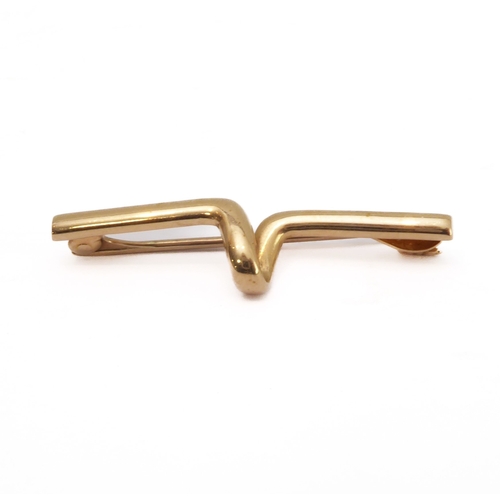 228 - A small 15-carat rose gold bar brooch of horizontal form and with a U-shaped outset bend to the cent... 