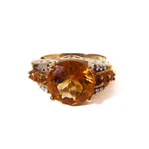 232 - A 9-carat yellow gold dress ring: centrally set with a good sized hand-cut citrine flanked by two di... 