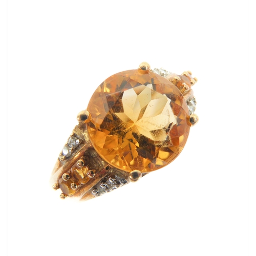 232 - A 9-carat yellow gold dress ring: centrally set with a good sized hand-cut citrine flanked by two di... 