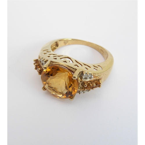 232 - A 9-carat yellow gold dress ring: centrally set with a good sized hand-cut citrine flanked by two di... 