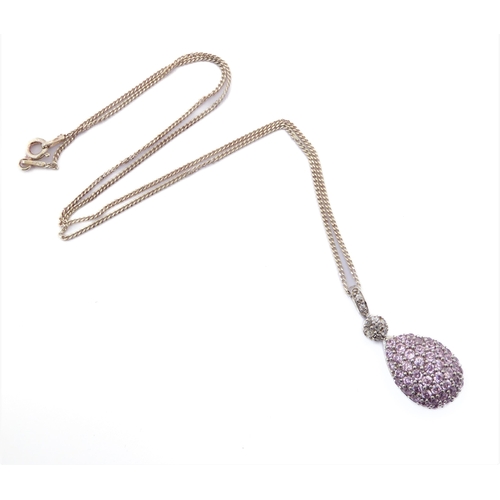 245 - A pear-shaped silver pendant set with a multitude of small hand-cut pink stones; the suspension loop... 