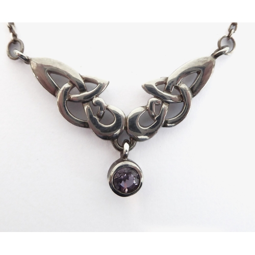 247 - A silver necklace pierced in Celtic style and with a single hand-cut circular amethyst-style dropper... 