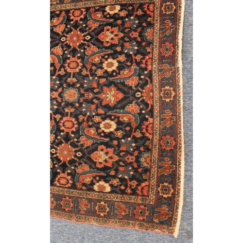 595 - A circa 1900 north-west Persian Feraghan rug; dark-blue field with Herati design in blue and red wit... 