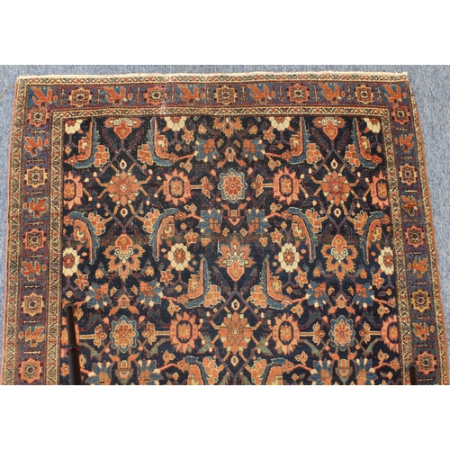 595 - A circa 1900 north-west Persian Feraghan rug; dark-blue field with Herati design in blue and red wit... 