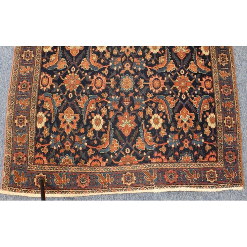 595 - A circa 1900 north-west Persian Feraghan rug; dark-blue field with Herati design in blue and red wit... 