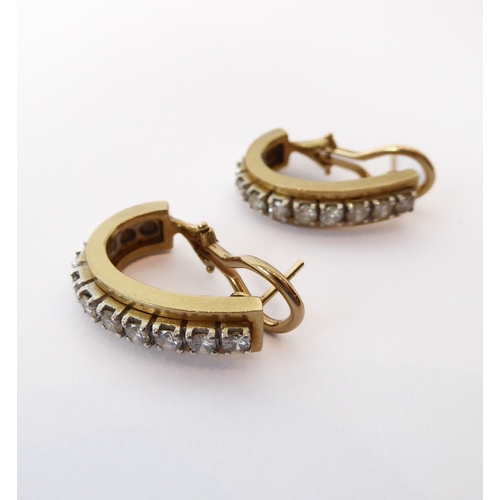 209 - A pair of 14ct two-colour gold and diamond half hoop earrings - each set with a row of nine brillian... 