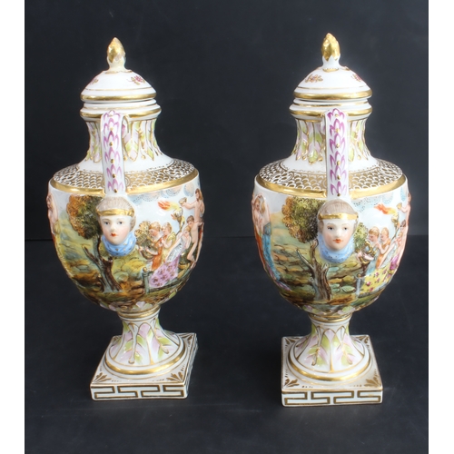 22 - A pair of late 19th century Capo di Monte porcelain urns and covers: hand-gilded and the handles wit... 