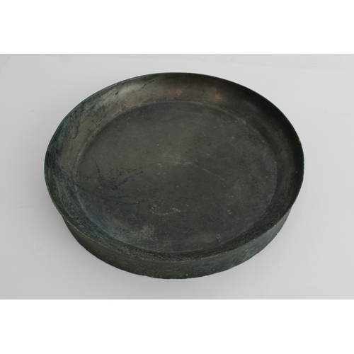 56 - An antique Chinese bronze mirror or dish: of dished circular form, the upper surface undecorated, th... 