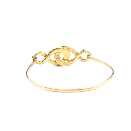 213 - An 18ct yellow gold and diamond bangle - unmarked, tests as 18ct, the open, interlaced scrollwork se... 